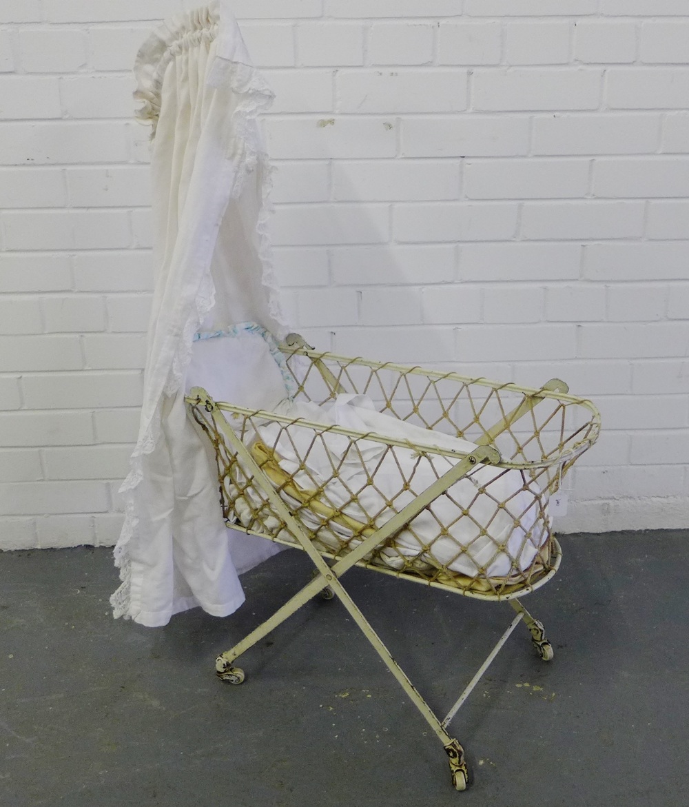 A Victorian white painted metal bassinet complete with canopy