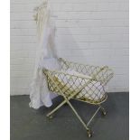 A Victorian white painted metal bassinet complete with canopy