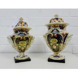 Two English pottery Imari pattern pot pourri urns, 19th century, with domed pierced covers above