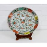 A Famille Verte shallow bowl of large proportions painted with flowers to the well and border on a