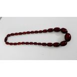 A graduated strand of faux cherry amber beads, approx 46cm long