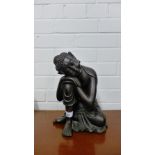 A patinated resin figure of a Buddha modelled seated, 26cm high