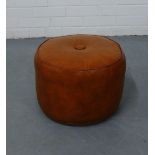 A circular brown leather footstool, diameter 36cm