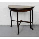 A mahogany and inlaid fold over card table, the circular top opening to reveal a green felt interior