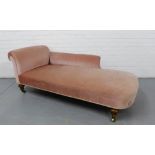 A scroll back chaise upholstered in pink velvet on turned rosewood supports terminating in brass