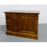 A contemporary hardwood side cabinet, the rectangular top over a bank of six small drawers flanked