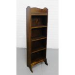 An oak narrow open bookcase with shaped side supports and five shelves, 120cm x 39cm