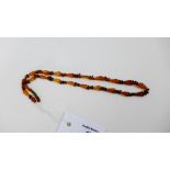 A vintage strand of facet amber beads with a screw fitting, length is 50cm with an overall approx