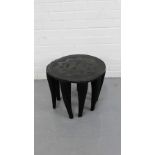 An African style stool, the circular top with curved star motif on nine tapering supports