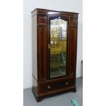 A mahogany and satin inlaid wardrobe, the pediment top over a central mirrored door fitted a