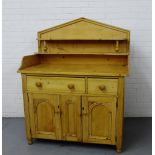 An antique pine ledgeback dresser with a shelf back over a rectangular top with a single long and