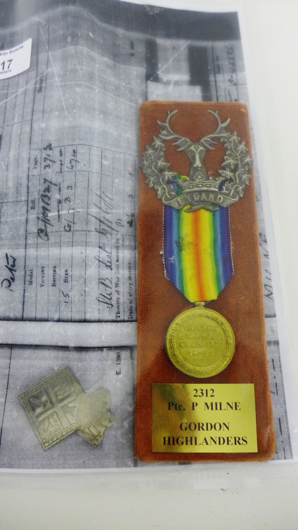 WWI Victory Medal, mounted with a Gordon Highlanders badge, awarded to Private P.Milne, No.2312 of