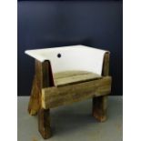 A novelty garden chair constructed from a cast white painted bath end on block timber supports, 70 x