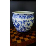 A blue and white Chinese planter with butterfly pattern together with a shaped hardwood base, 30 x