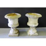 A pair of grey painted weathered stone antique garden urns of campana form on acanthus leaf pedestal