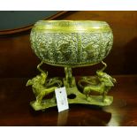 A brass embossed decorated bowl on an accompanying stand having three mythical beast supports,