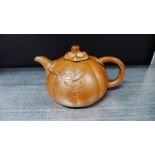 A Yixing style teapot of load globular form applied with leaf decoration, 10cm high