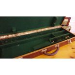 A veneered wood gun case with leather carry handle