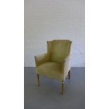 An upholstered wing armchair on beechwood supports