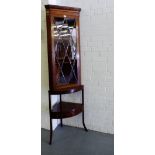 A mahogany corner cabinet, the dentil top over glazed panel door enclosing a shelved interior on a