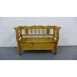 A pine spindle back bench, the seat with a lift up compartment, 90 x 128cm