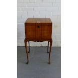 A walnut sewing table, the hinged top with quarter veneers lifting to reveal a void interior all