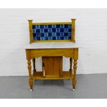 A pine ledgeback wash stand with a blue tiled splash back over a marble rectangular top with a