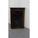 A 19th century mahogany and paterae inlaid corner cabinet, the shaped pediment top over a glazed