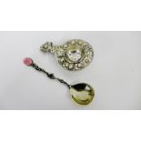 A white metal strainer with rose bud repousee decoration together with a cast white metal spoon with