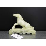 A white soapstone figure of a horse on a shaped plinth base, 18 x 14cm