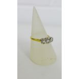 An illusion three stone diamond dress ring with gold band