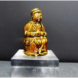 A treacle glazed money bank modelled as a tavern drinking gent seated with a jug of ale, 13cm high