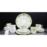 An Art Nouveau white glazed porcelain teaset painted with stylised flowers in green and blue