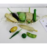 A collection of carved bone miniature vegetables, some stained green, to include a chili, a corn