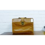 A vintage tan leather briefcase with brass clasps