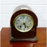 A mahogany cased dome topped mantle clock, the silvered dial with Arabic numerals, flanked by