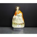 A Staffordshire flat back figure of Little Red Riding Hood on an oval gilt lined base, 23cm high