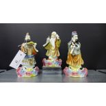 A collection of three porcelain figures decorated in coloured enamels on rock work bases, tallest