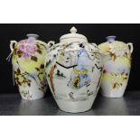 A pair of Japanese porcelain twin handled baluster vases decorated with Chrysanthemums, together