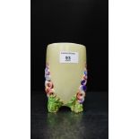 A Clarice Cliff Wilkinsons pottery Hollyhocks vase on tripod supports, with printed back stamps to