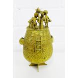 An Ashanti brass gold dust pot, the ovoid body with incised geometric bands, the lid surmounted by