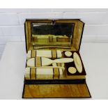 An Edwardian leather cased vanity set containing a set of ivorine handled accessories to include