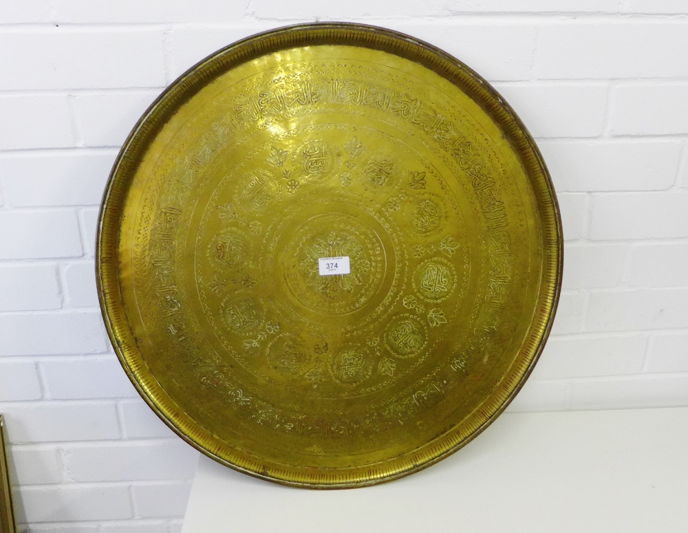 An Eastern circular brass charger with calligraphy and foliate engraved pattern, 58cm diameter