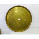 An Eastern circular brass charger with calligraphy and foliate engraved pattern, 58cm diameter