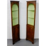 A pair of early 20th century mahogany corner cabinets with pediment top over an arched open alcove