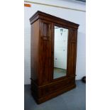 A mahogany wardrobe, the pediment top over a central mirrored panel door opening to reveal a