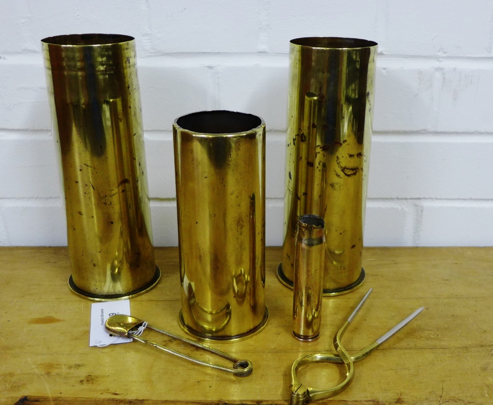 Four brass shell cases, together with a novelty brass safety pin and a pair of tongs (6)