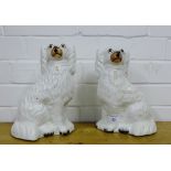 A pair of white glazed Staffordshire chimney spaniels with painted faces and gilt collars and