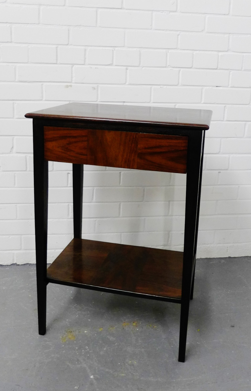 A rosewood side table, the rectangular top over a single drawer on tapering supports with undertier,