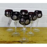 A set of six wine glasses, the ruby coloured bowls with star cut decoration on facet stems and